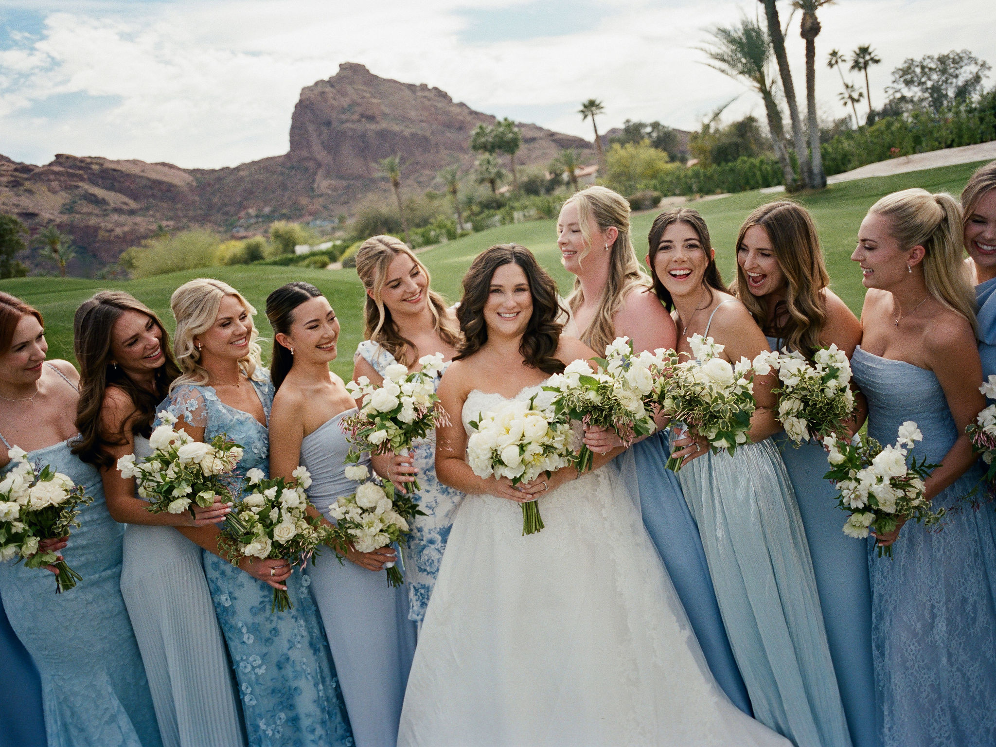 Taylor laughing with her bridesmaids beneath the mountains, photographed on film.