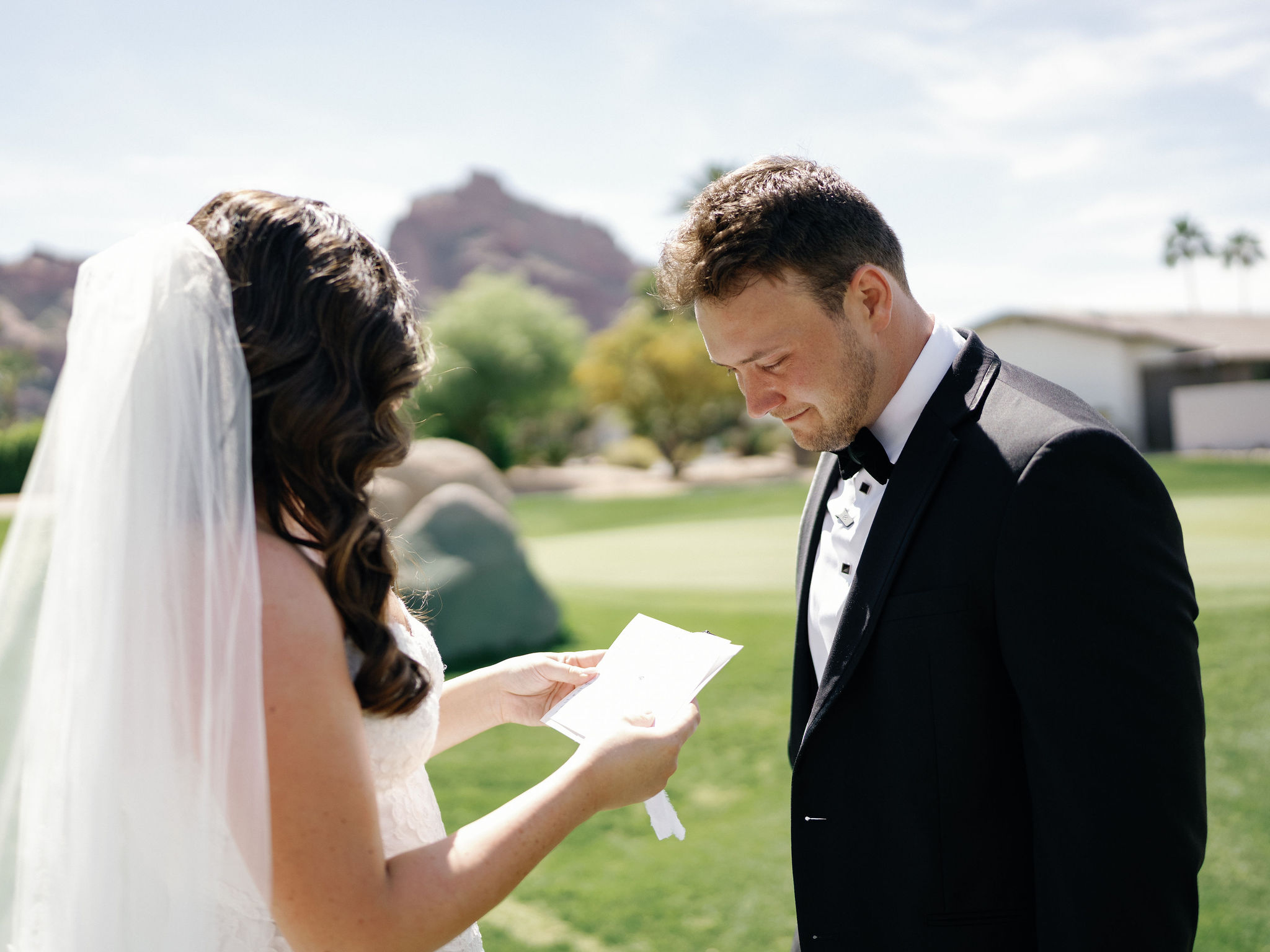 Ryan listening as Taylor reads from a handwritten page on the lawn.