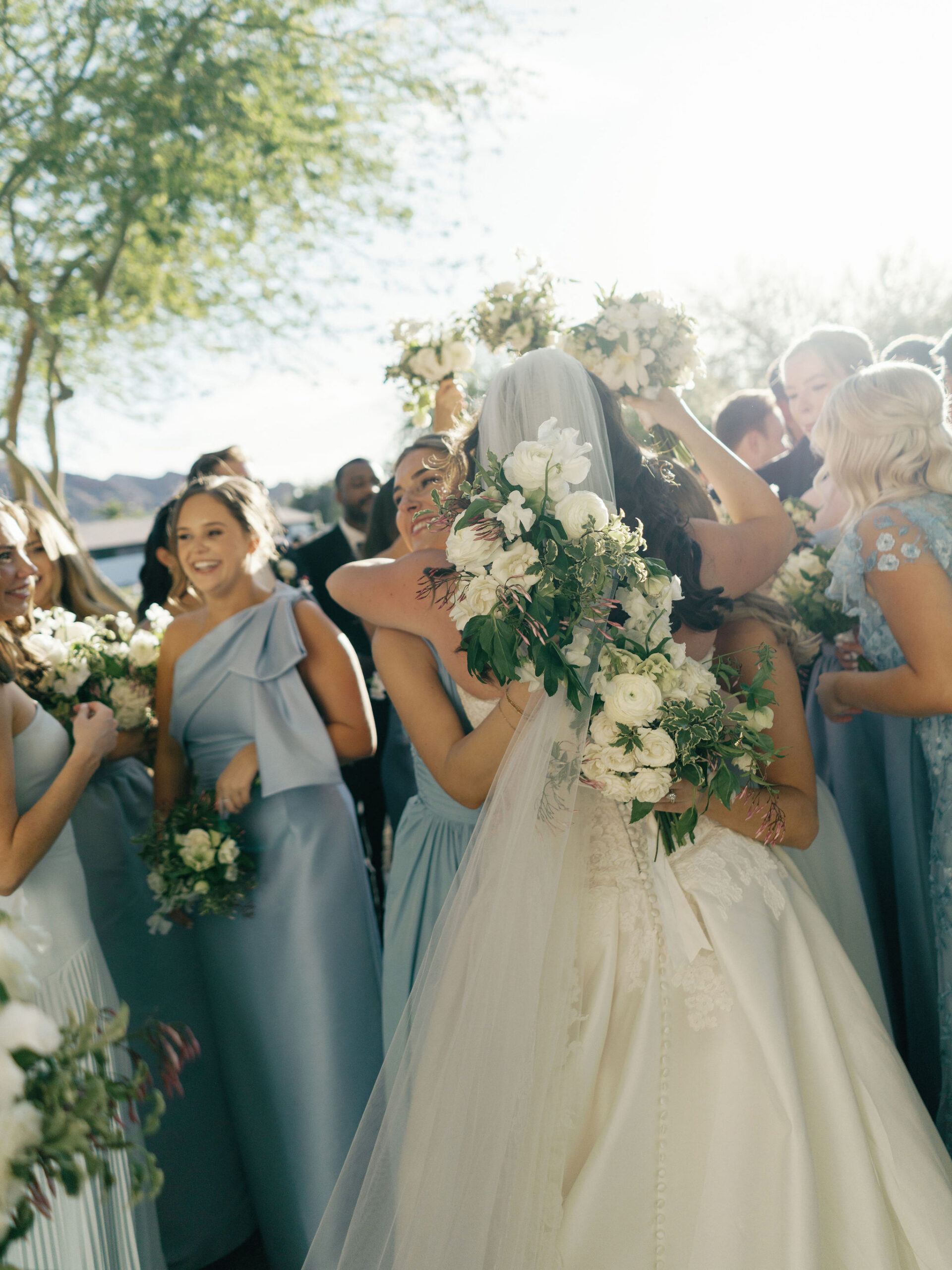 Friends gathering around Taylor for hugs after the ceremony.