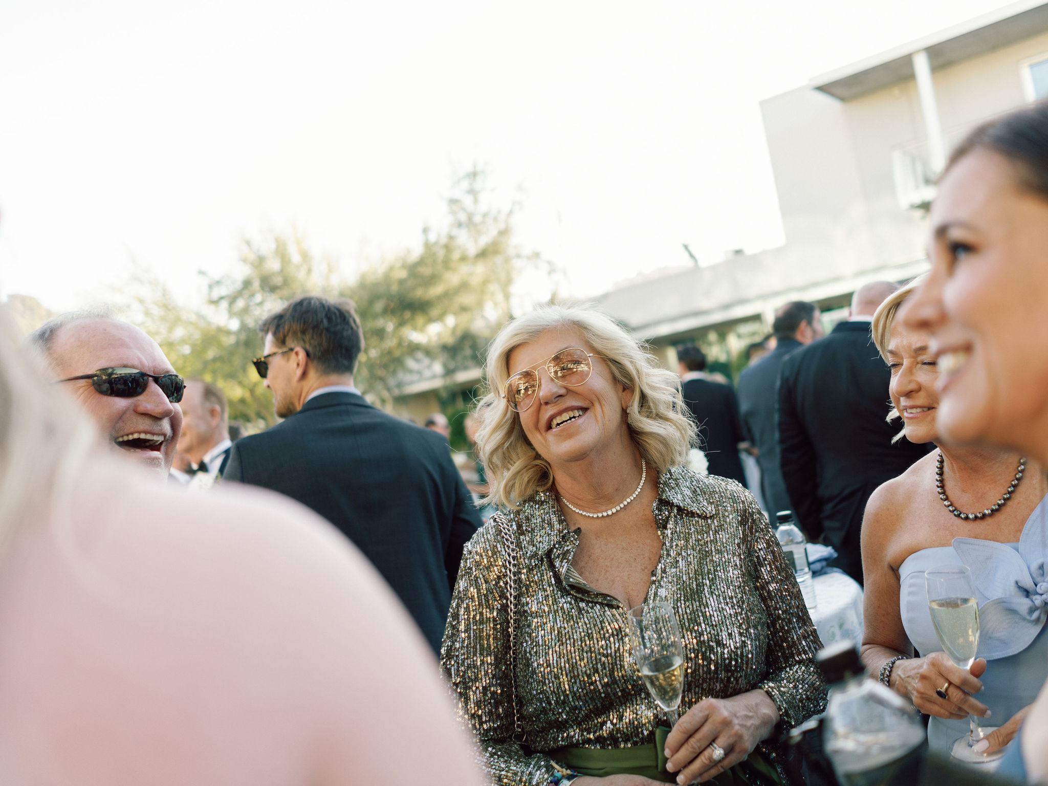 Wedding guests laughing together in a layered candid photograph.
