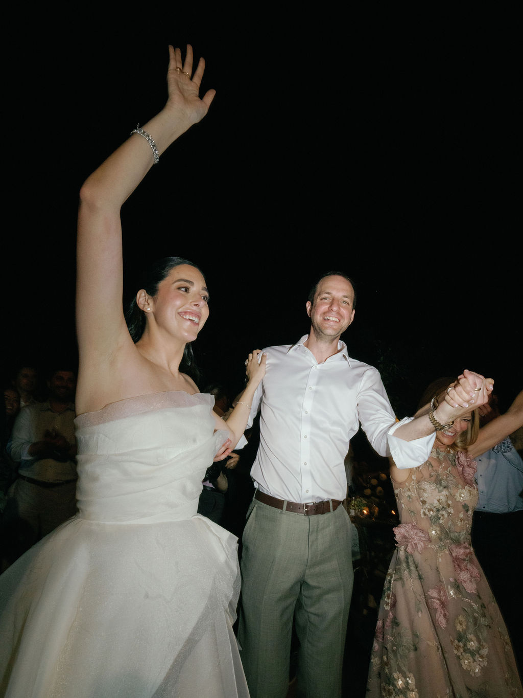 Newlyweds dancing with family during the reception