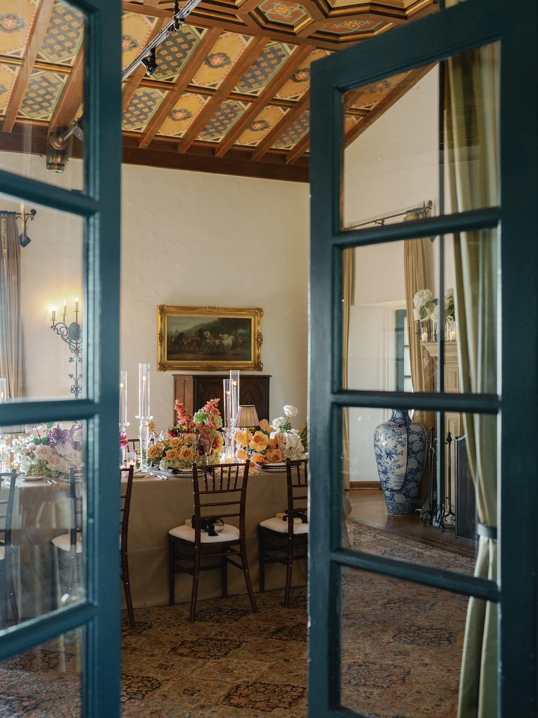 Teal glass doors opening onto the warm dining room set for dinner